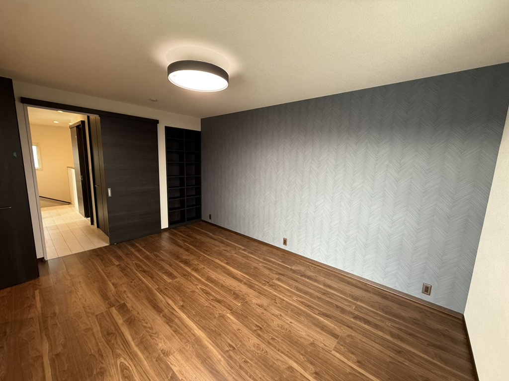 No.3/落ち着いた色調の壁紙で心もゆったり休めそうな寝室。作り付けの棚があり、本などの収納にも困りません(25年12月撮影)